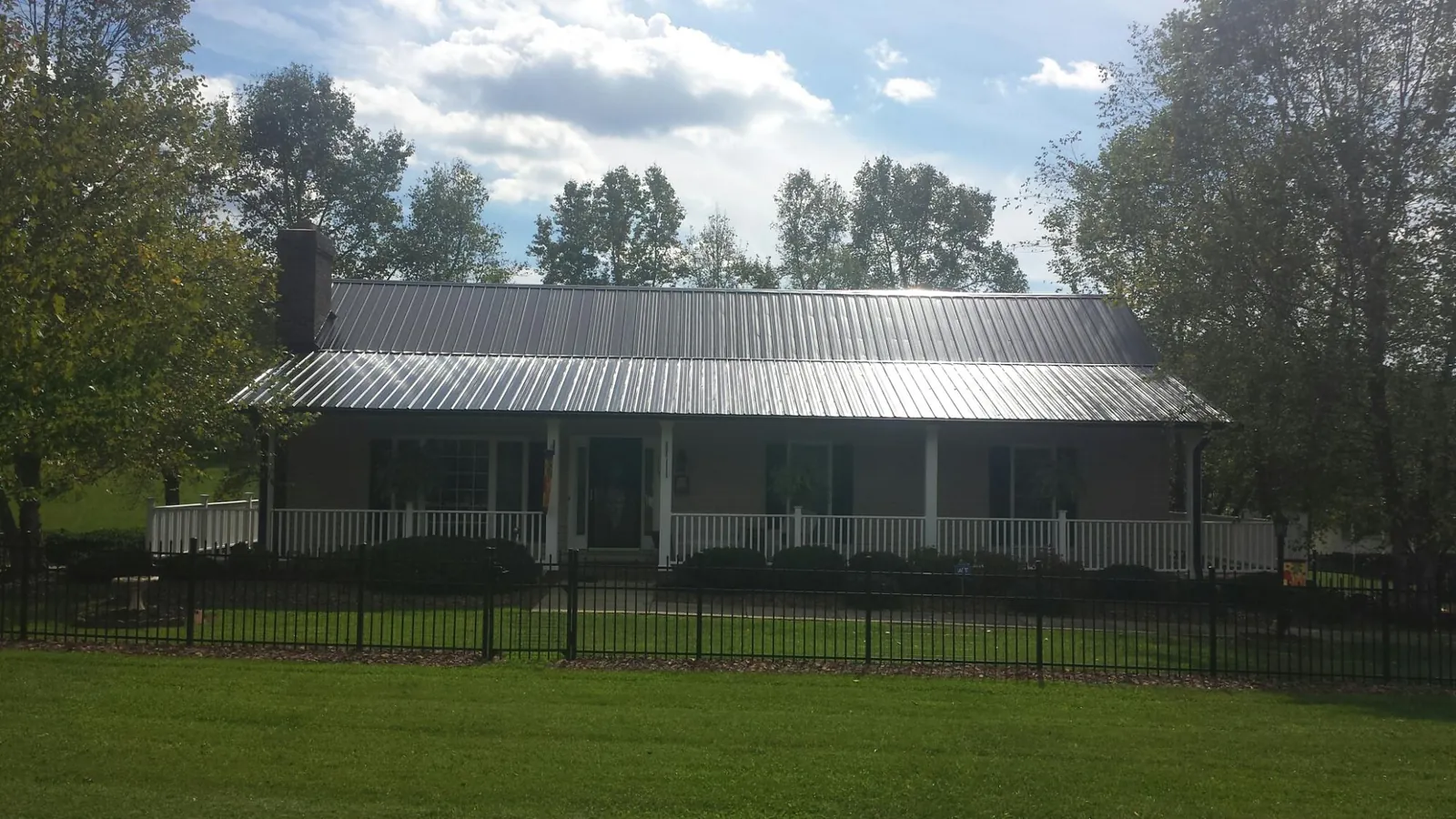 Gray metal roof on a brick ranch with a full width front porch — Gutter Guard Installation work by our crew in Royston