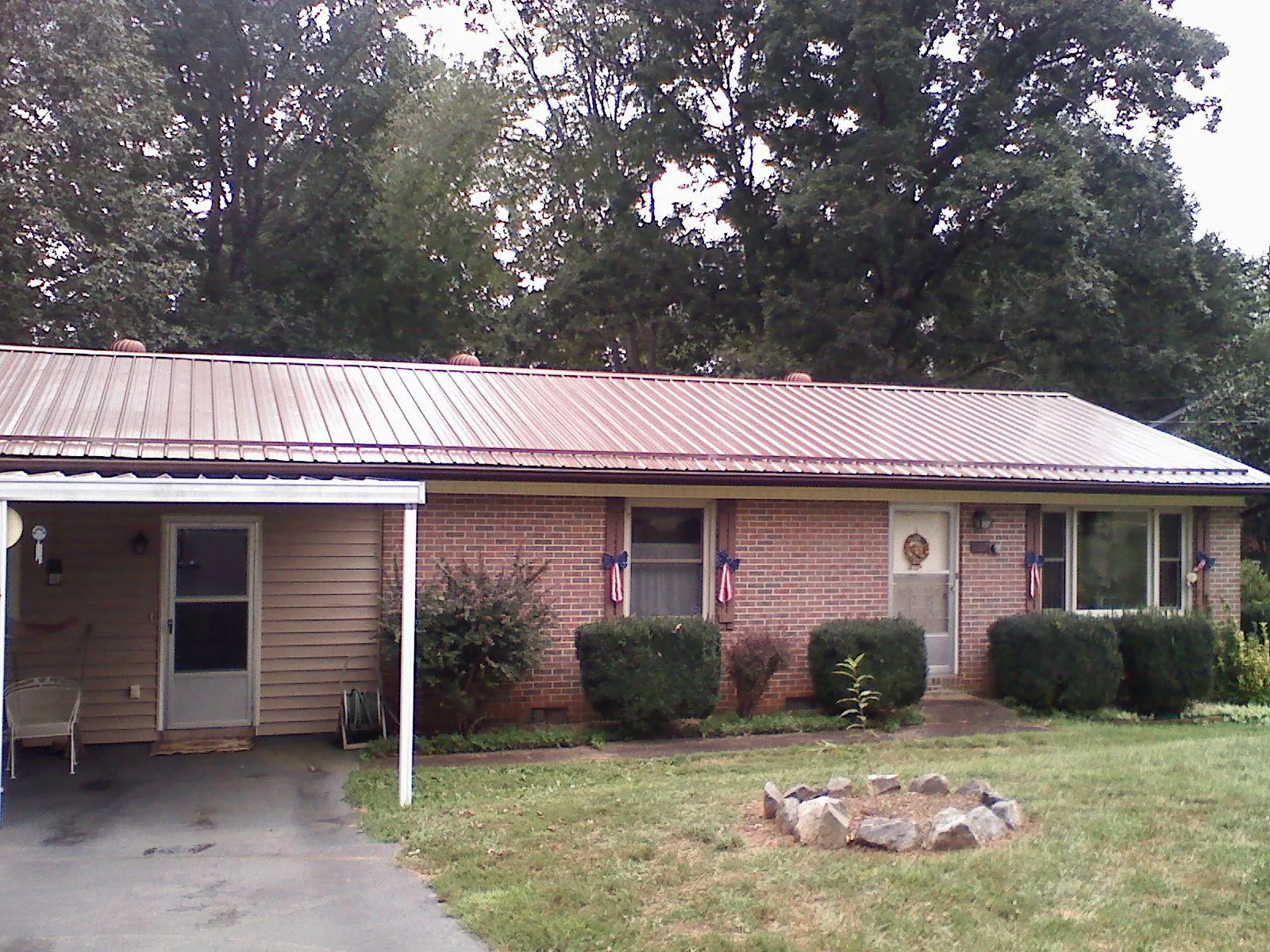 Bronze metal roof and carport on a brick ranch home — Roof Repair work by our crew in Royston